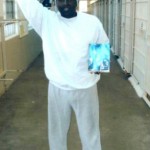 Kenny Zulu Whitmore holding the autobiography of Angola Three member Robert Hillary King